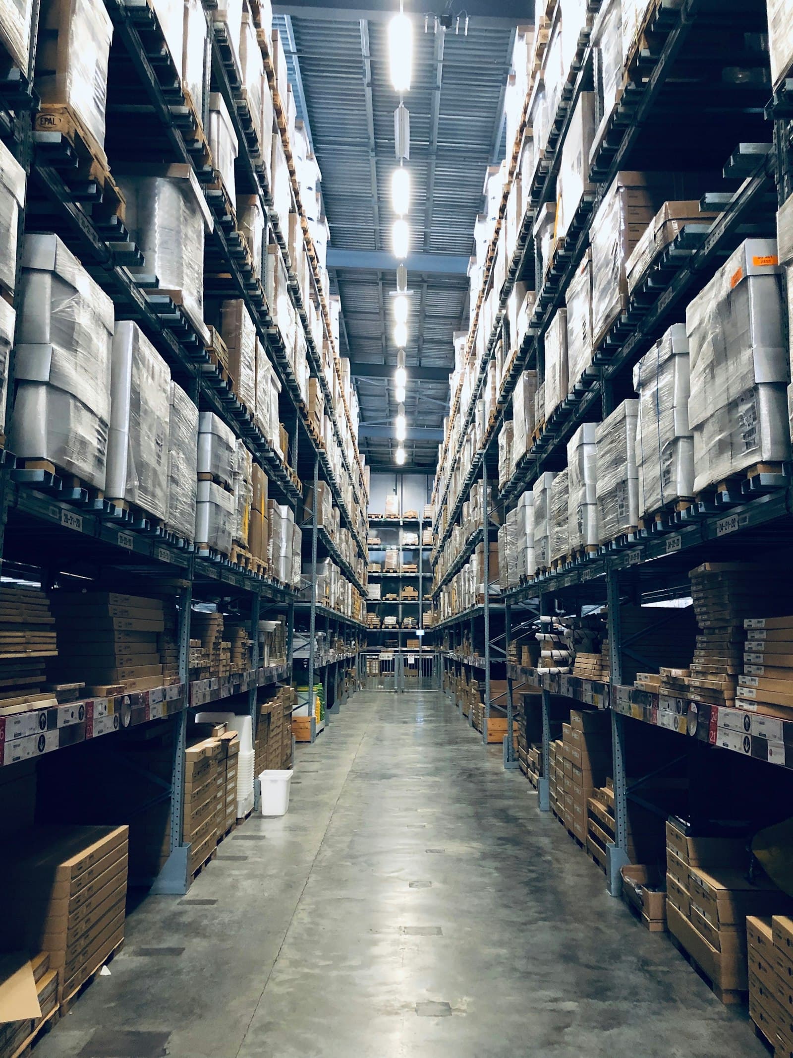 Allée d’entrepôt où les lots sont rangés avant livraison.